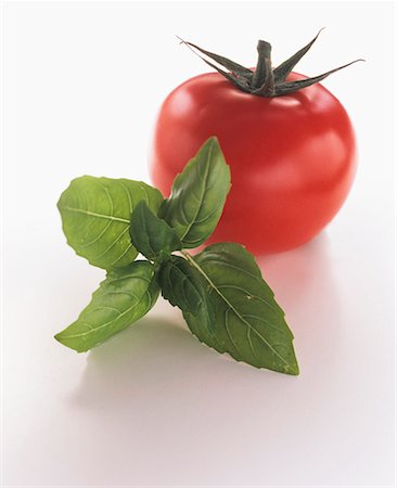 simsearch:659-03522999,k - Une tomate avec un brin de basilic Photographie de stock - Premium Libres de Droits, Code: 659-01842339