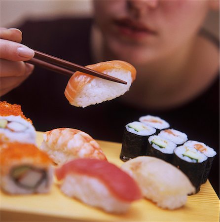 simsearch:659-02212373,k - Une personne qui détient un Nigiri Sushi sur baguettes Photographie de stock - Premium Libres de Droits, Code: 659-01842688