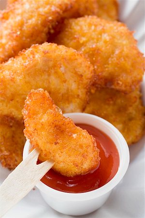 simsearch:659-01862628,k - Dipping chicken nugget into ketchup with wooden fork Foto de stock - Sin royalties Premium, Código: 659-01842881