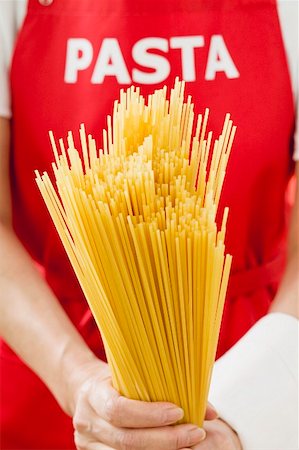 Spaghetti, person with 'pasta' apron in background Stock Photo - Premium Royalty-Free, Code: 659-01842901