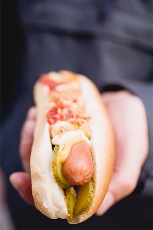 Hand holding a hot dog Stock Photo - Premium Royalty-Free, Code: 659-01842912