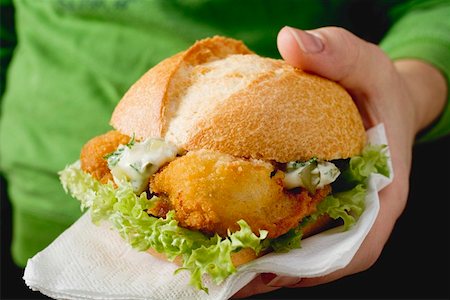simsearch:659-01850108,k - Hand holding fish burger with remoulade sauce Stock Photo - Premium Royalty-Free, Code: 659-01842922