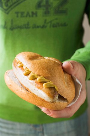 sausage sandwich - Hand holding sausage and mustard in a bread roll Stock Photo - Premium Royalty-Free, Code: 659-01842941