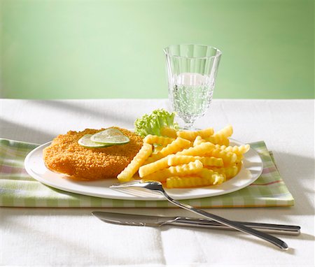 simsearch:659-03528204,k - Wiener Schnitzel with lime slices chips & glass of water Stock Photo - Premium Royalty-Free, Code: 659-01843001