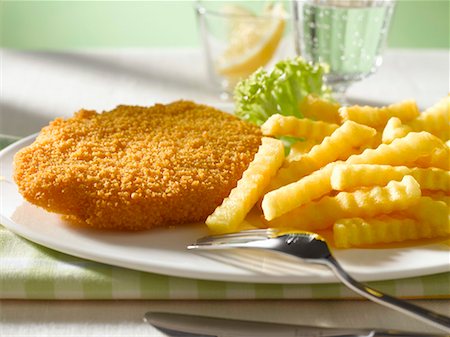 Wiener Schnitzel (breaded veal escalope) with chips Stock Photo - Premium Royalty-Free, Code: 659-01843002