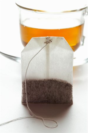 Tea bag in front of a cup of tea Stock Photo - Premium Royalty-Free, Code: 659-01843075