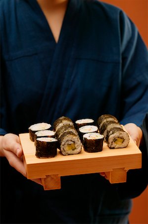 simsearch:659-01843268,k - Person in blue kimono serving maki-sushi Foto de stock - Sin royalties Premium, Código: 659-01843269