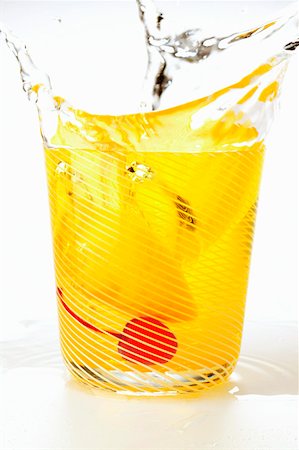 Tonic with lemon and cocktail cherry splashing out of glass Stock Photo - Premium Royalty-Free, Code: 659-01843289