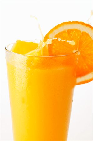 simsearch:659-06187271,k - Orange juice splashing out of glass Foto de stock - Sin royalties Premium, Código: 659-01843295