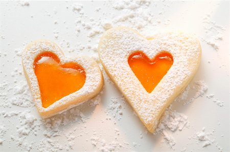 simsearch:659-01843444,k - Sweet pastry hearts with apricot jam and icing sugar Fotografie stock - Premium Royalty-Free, Codice: 659-01843448