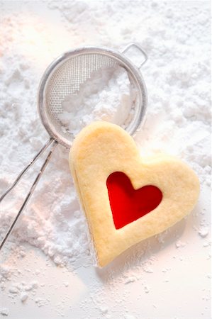 Sweet pastry heart with raspberry jam on icing sugar Stock Photo - Premium Royalty-Free, Code: 659-01843450