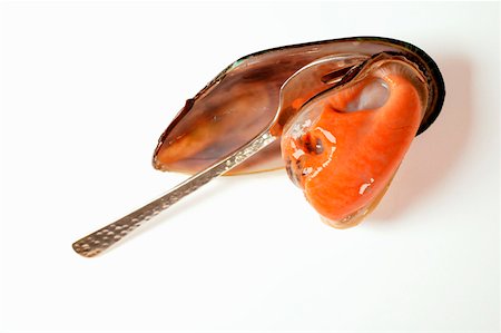 Taking New Zealand mussel out of its shell Stock Photo - Premium Royalty-Free, Code: 659-01843597