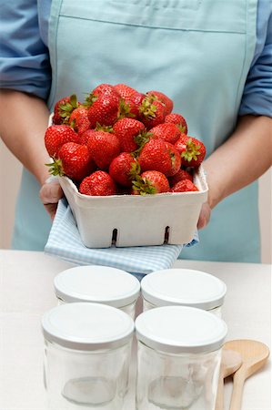 Woman holding punnet of strawberries, jam jars Stock Photo - Premium Royalty-Free, Code: 659-01843969