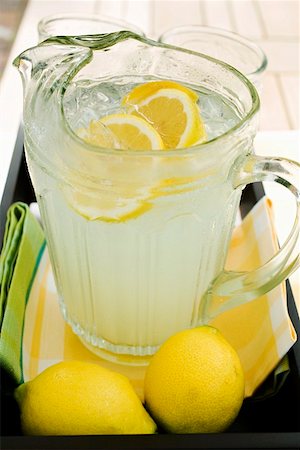 Lemonade in a glass jug with slices of lemon and ice Stock Photo - Premium Royalty-Free, Code: 659-01854119