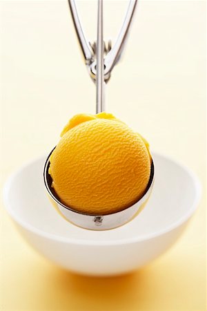 Mango sorbet in an ice cream scoop Stock Photo - Premium Royalty-Free, Code: 659-01854143