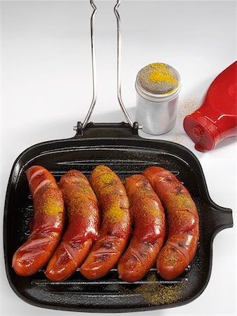 recipes on grill pan - Five currywurst (sausages with ketchup & curry powder)in grill pan Stock Photo - Premium Royalty-Free, Code: 659-01854337