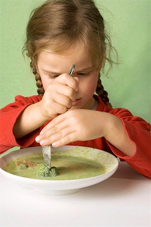 Girl cutting a broccoli floret in vegetable soup Stock Photo - Premium Royalty-Free, Code: 659-01854458