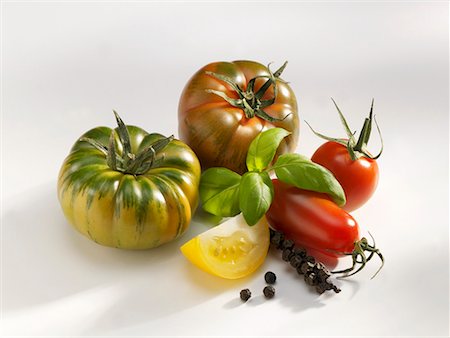 striped tomato - Various types of tomatoes with basil and bunch of pepper Stock Photo - Premium Royalty-Free, Code: 659-01854452