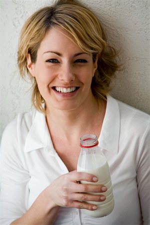 simsearch:659-03523361,k - Young woman holding a bottle of milk in her hand Stock Photo - Premium Royalty-Free, Code: 659-01854556