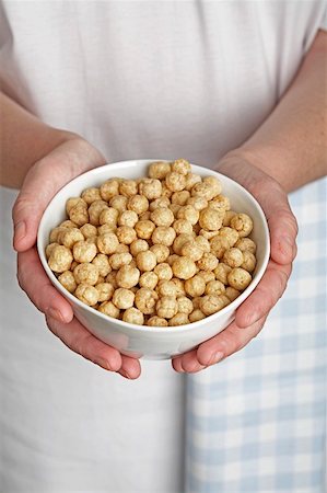 Hands holding a bowl of toasted rice breakfast cereal Stock Photo - Premium Royalty-Free, Code: 659-01854562