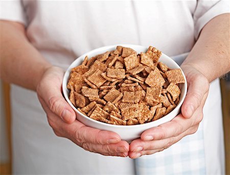 Hands holding a bowl of cinnamon flavoured breakfast cereal Stock Photo - Premium Royalty-Free, Code: 659-01854579