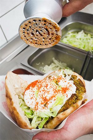 Adding spicy seasoning to a döner kebab Stock Photo - Premium Royalty-Free, Code: 659-01854661