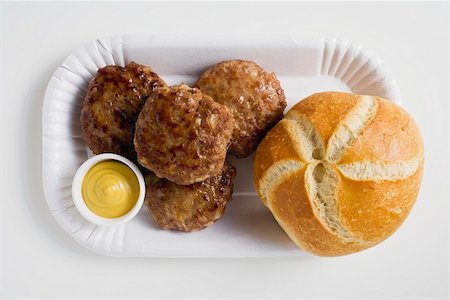 Four burgers with mustard and bread roll Stock Photo - Premium Royalty-Free, Code: 659-01854688