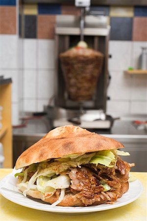 doner kebab recipe - A döner kebab with meat on spit in background Stock Photo - Premium Royalty-Free, Code: 659-01854713