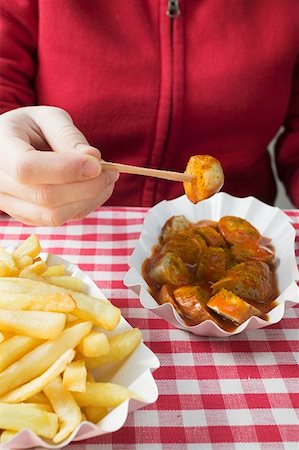 dining at germany - Person eating currywurst with chips Stock Photo - Premium Royalty-Free, Code: 659-01854788