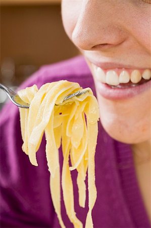 simsearch:659-01863088,k - Woman eating ribbon pasta Foto de stock - Sin royalties Premium, Código: 659-01854792