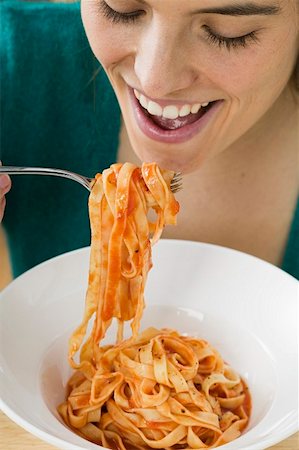 simsearch:659-01863088,k - Woman eating ribbon pasta with tomato sauce Foto de stock - Sin royalties Premium, Código: 659-01854793