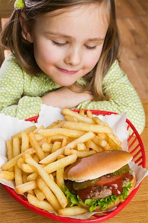 Small girl with hamburger and chips Stock Photo - Premium Royalty-Free, Code: 659-01854820
