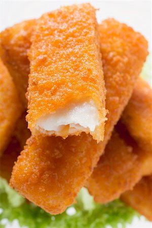 fried fish food - Fish finger with a bite taken on a heap of fish fingers Stock Photo - Premium Royalty-Free, Code: 659-01855077