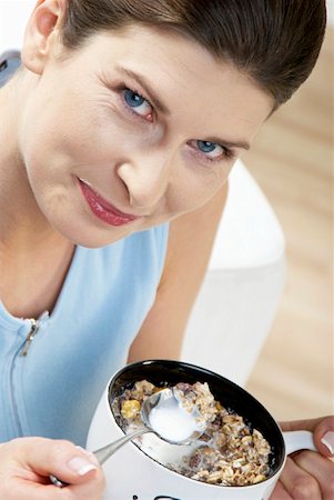 Woman eating chocolate muesli with milk Stock Photo - Premium Royalty-Free, Code: 659-01855236