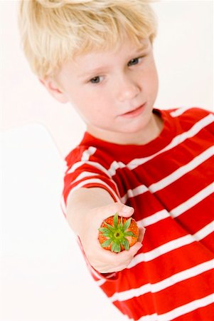 simsearch:659-01866601,k - Blond boy with a strawberry in his hand Foto de stock - Royalty Free Premium, Número: 659-01855585