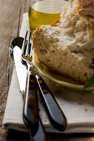 Pieces of white bread on plate, cutlery, olive oil Stock Photo - Premium Royalty-Free, Code: 659-01857208