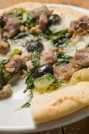 silver beet - Pizza with tuna, chard and olives a slice taken Stock Photo - Premium Royalty-Free, Code: 659-01857312