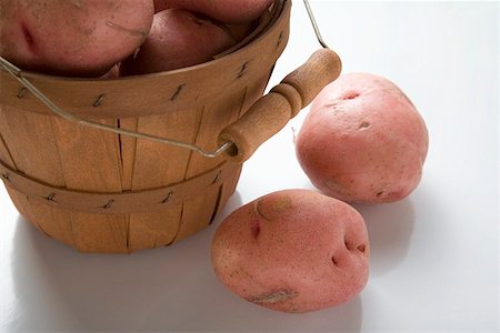 Red potatoes in and beside woodchip basket Stock Photo - Premium Royalty-Free, Code: 659-01857371