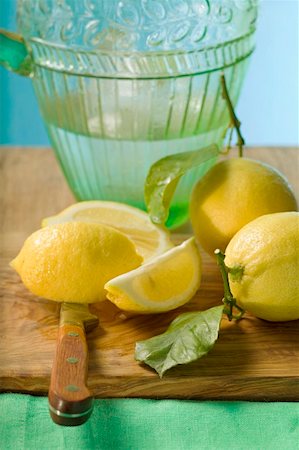 simsearch:659-01857464,k - Fresh lemons with leaves in front of water jug Stock Photo - Premium Royalty-Free, Code: 659-01857465