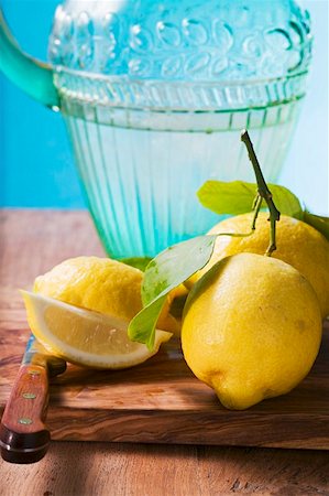 simsearch:659-01857464,k - Fresh lemons with leaves in front of water jug Stock Photo - Premium Royalty-Free, Code: 659-01857466