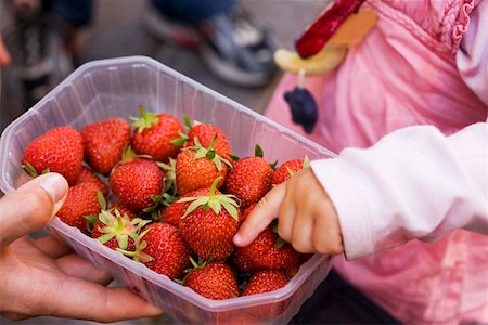 simsearch:659-01864546,k - Child's hand reaching for strawberries in a plastic punnet Stock Photo - Premium Royalty-Free, Code: 659-01857641