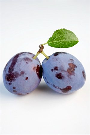 prunus domestica - Two plums with stalk and leaf Foto de stock - Sin royalties Premium, Código: 659-01857697