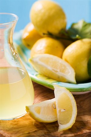 simsearch:659-01857464,k - Several lemons with leaves, lemon wedges, lemon juice Stock Photo - Premium Royalty-Free, Code: 659-01857795