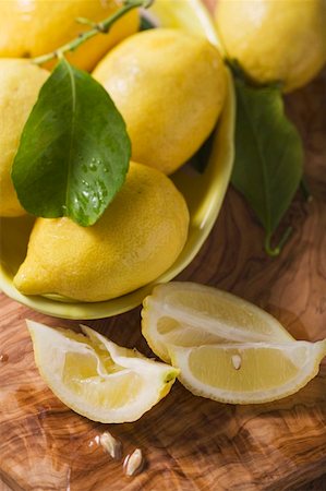 Lemon wedges and lemons with leaves Stock Photo - Premium Royalty-Free, Code: 659-01857805