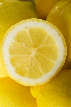 simsearch:659-01864171,k - Lemon half on whole lemons (close up) Foto de stock - Sin royalties Premium, Código: 659-01857810