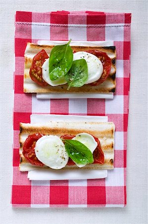 simsearch:659-01857570,k - Two tomato and mozzarella toasts with basil Foto de stock - Sin royalties Premium, Código: 659-01857996