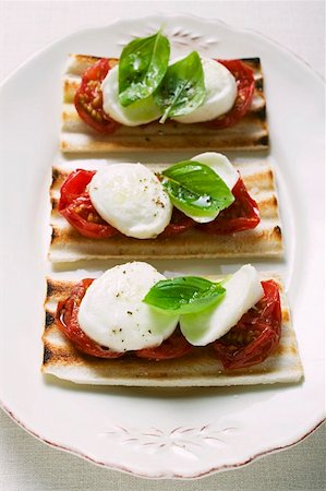 simsearch:659-03525182,k - Three tomato and mozzarella toasts with basil Stock Photo - Premium Royalty-Free, Code: 659-01857992