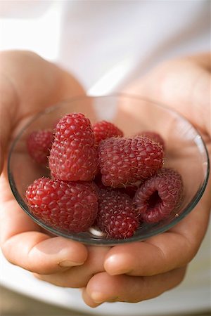 simsearch:659-01857965,k - Hands holding small bowl of fresh raspberries Foto de stock - Sin royalties Premium, Código: 659-01858083