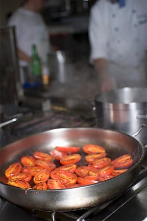 simsearch:659-01858205,k - Tomatoes in frying pan on stove, chefs in background Foto de stock - Sin royalties Premium, Código: 659-01858190