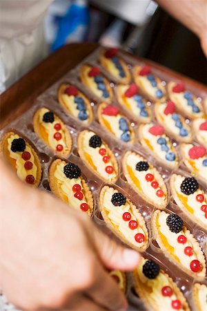 Chef holding tray of assorted berry tartlets Stock Photo - Premium Royalty-Free, Code: 659-01858210